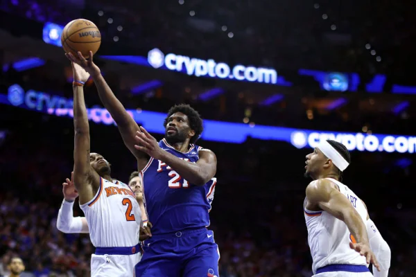 Joel Embiid #21 do Philadelphia 76ers faz arremesso entre jogadores do New York Knicks