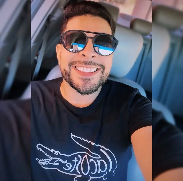 homem sorrindo de óculos escuros