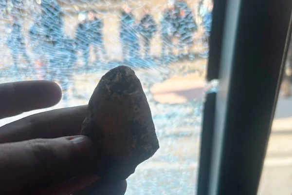 Imagem colorida de pedra atirada na direção do ônibus do Athletico-PR- MEtrópoles