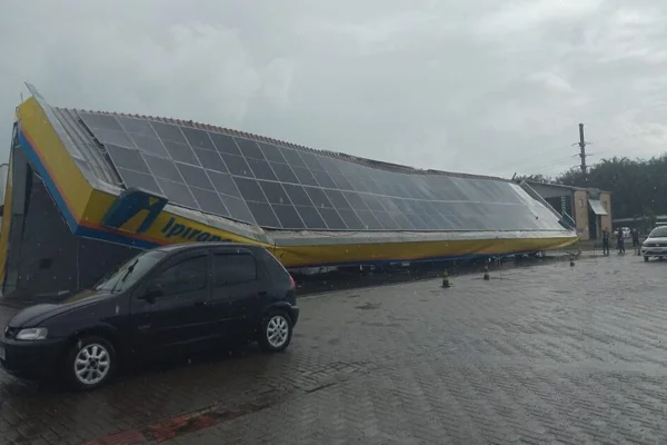 Imagem colorida, estrutura de posto caída encima de um carro - Metrópoles