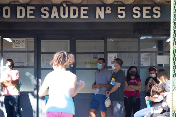 Pessoas em frente a prédio de centro de saúde