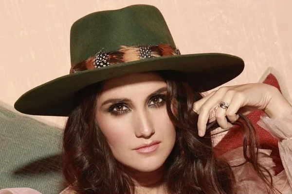 Foto colorida de Dulce María com chapéu verde - Metrópoles