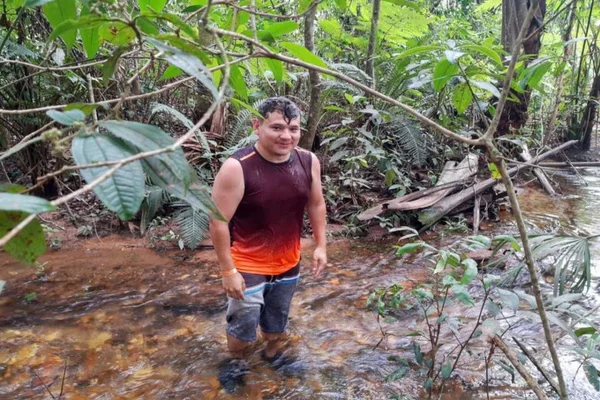 Homem em pé dentro de um rio