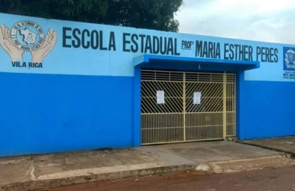 fachada de uma escola pública pintada de azul com portões amarelos