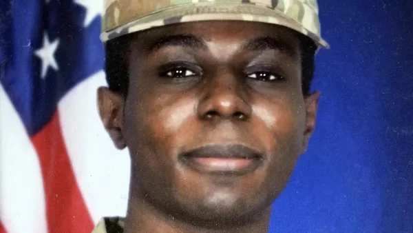 Imagem colorida mostra Travis King, soldado estadunidense que entrou na Coreia do Norte, em uma foto em frente à bandeira dos EUA - Metrópoles
