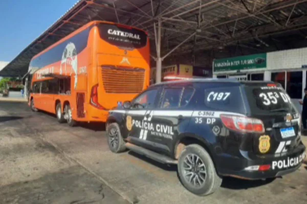 ônibus interestadual e viatura em terminal rodoviário