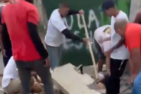 Foto colorida de pessoas tentando resgatar vítimas de queda de muro no Rio após forte ventania - Metrópoles