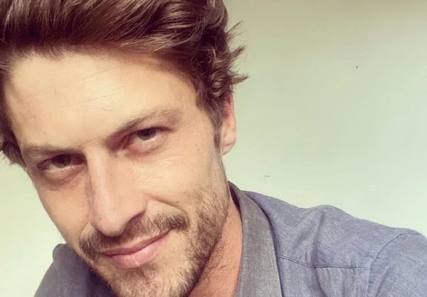 foto colorida do ator Ricardo Merini, com camiseta cinza e barba rala - Metrópoles