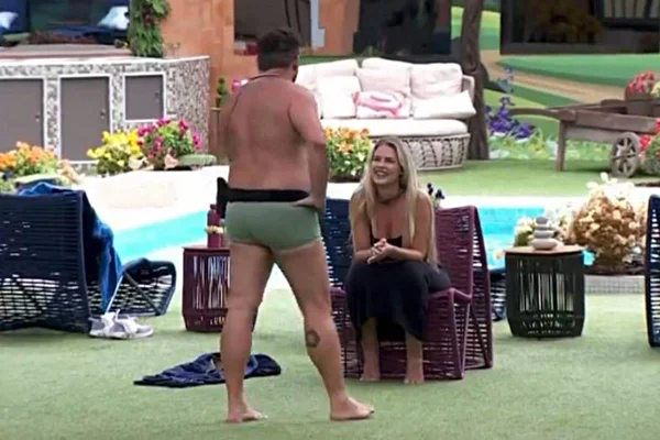foto colorida de yasmin brunet sentada e michel de sunga em pé falando com ela - metrópoles