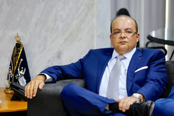 Homem de terno azul sentado em sofá
