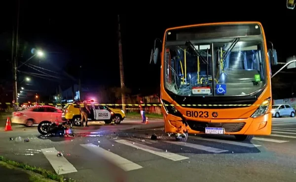 Imagem colorida do acidente. É possível ver o ônibus e a moto caída no chão - Metrópoles