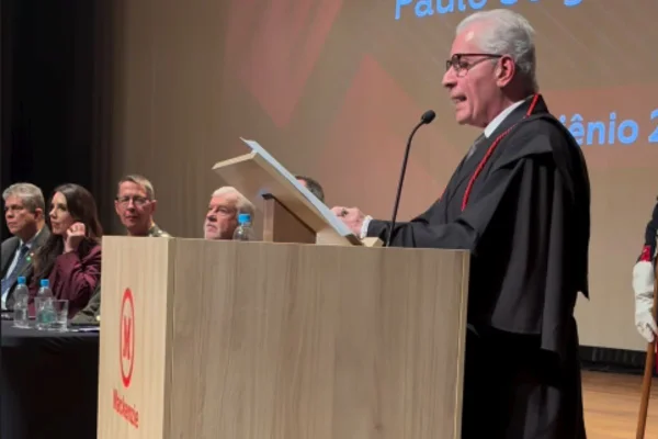 Imagens coloridas mostram homem branco, de toga, discursando em púlpito durante evento de posse