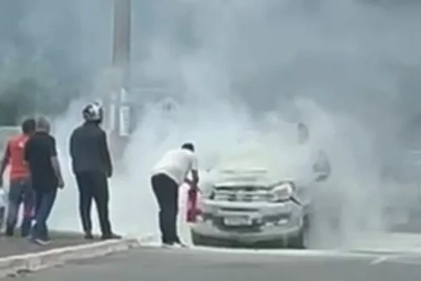 Carro pega fogo e pedestres usam extintores para apagar incêndio