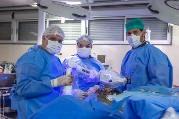 Imagem colorida de equipe médica responsável por cirurgia robótica