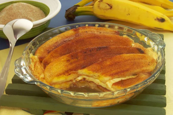 Assadeira de vidro transparente com bananas salpicadas de canela