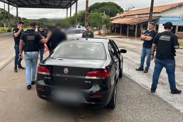 Foto colorida de carro com homem preso