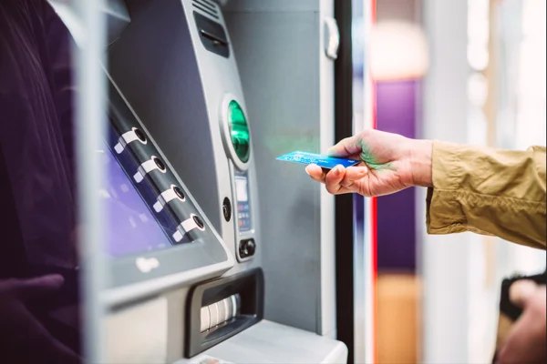 Imagem de cliente fazendo pagamento em caixa eletrônico de banco - Metrópoles