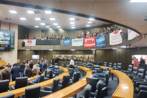 Imagem colorida mostra plenário da Cãmara de Vereadores de SP e, no mezanino, cartazes coloridos pendurados em protesto - Metrópoles
