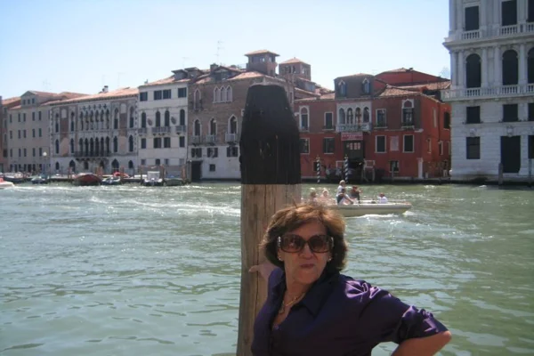 Professora pioneira no DF, Marta Cintra, em foto na beira de um lago, escorada em uma estaca olhando para a câmera. Ela faleceu nesta (20/07) - Metrópoles