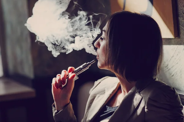 Mulher fumando cigarro eletrônico, vape. Metrópoles
