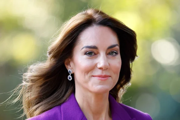 Foto colorida de mulher com cabelo ao vento. Ela usa uma roupa na cor roxa - Metrópoles