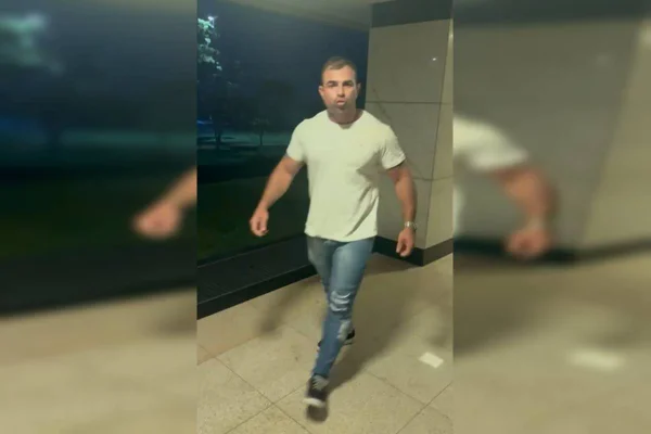 Foto colorida de homem andando em pilotis
