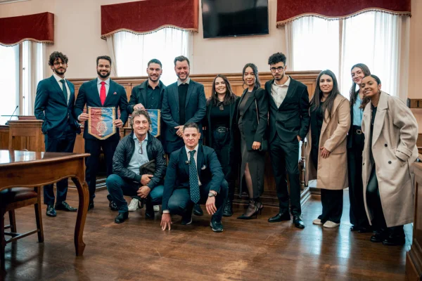 Fotografia colorida mostrando várias pessoas posando para foto em sala de reunião-Metrópoles