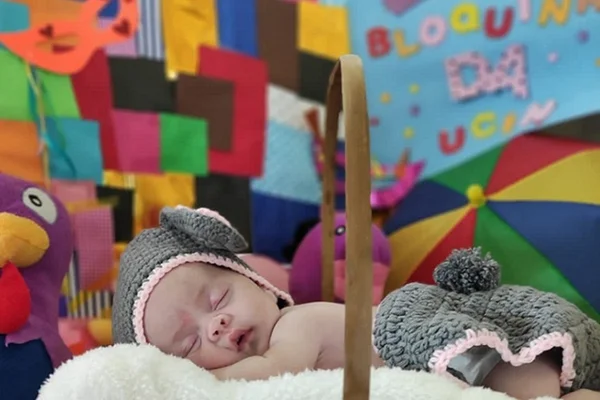 Bebê deitado, dormindo, em ambiente colorido