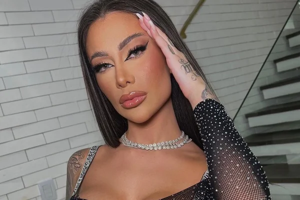 Foto colorida da DJ Gabi Cavallin - Ela tem olhos claros, cabelo preto e é branca. A artista usa um colar de brilhantes e uma roupa transparente - Metrópoles