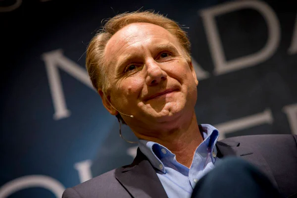 Imagem colorida de Dan Brown sorrindo em evento - Metrópoles