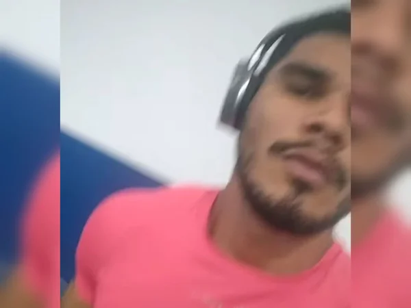 Imagem colorida de homem com fone de ouvido e camiseta vermelha - Metrópoles