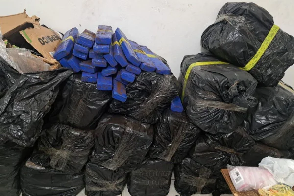 Imagem colorida mostra sacos pretos empilhados contra parede branca. No topo estão sacos da cor azul - Metrópoles