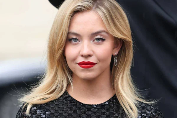 rosto da atriz Sydney Sweeney , que é loira e usa batom vermelho - metrópoles