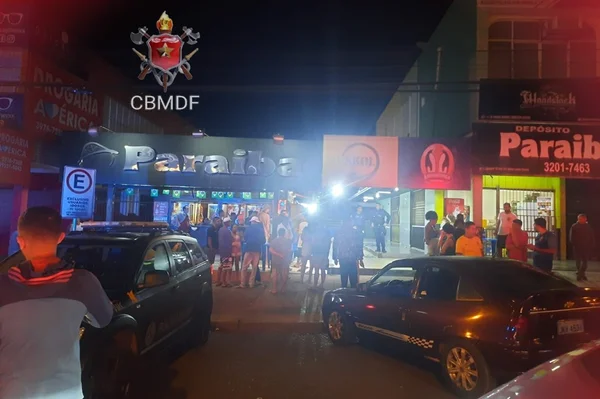 Carros em frente a bar à noite e luzes