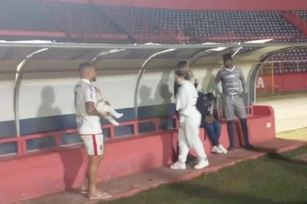 Pessoas em frente a banco de reservas em estádio