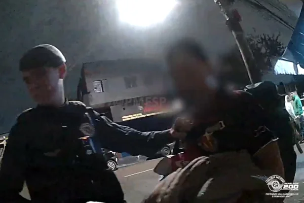 Imagem colorida de PM prendendo homem. Metrópoles