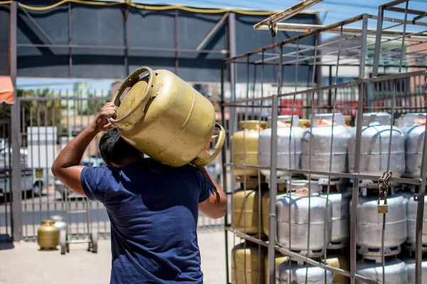Imagem colorida, homem segurando um gás de cozinha - Metrópoles