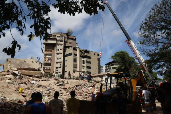 Pessoas e equipes de resgate trabalham nos escombros do edifício Moises, na Avenida Anauco, após um terremoto de magnitude 7,2 atingir a Venezuela