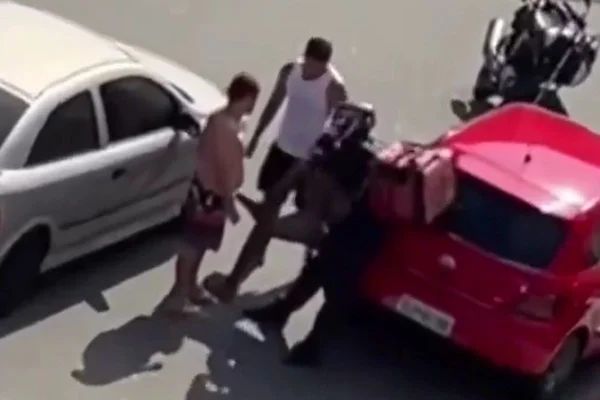 Imagem colorida mostra motociclista aplicando um mata-leão em um suspeito de cometer uma assalto em Praia Grande, no litoral de São Paulo - Metrópoles
