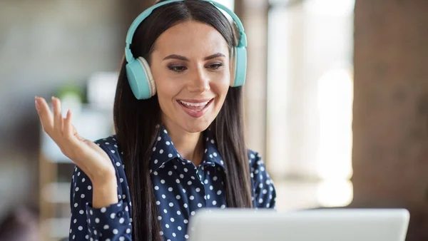 Mulher com fone de ouvido fazendo entrevista de emprego pelo computador