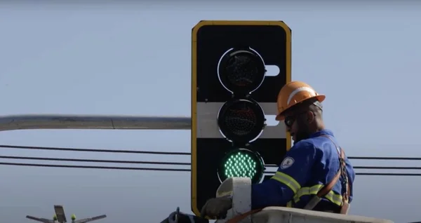 foto colorida de funcionário instalando semáforo inteligente em SP
