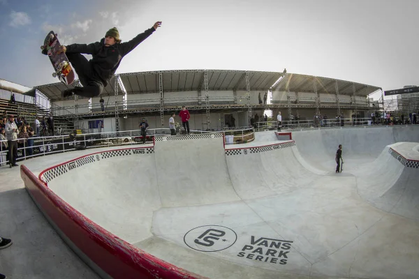 Homem faz manobra em pista de skate park