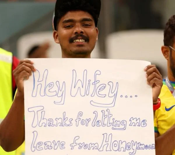 torcedor segura cartaz agradecendo esposa por deixá-lo ver o jogo Brasil x Camarões