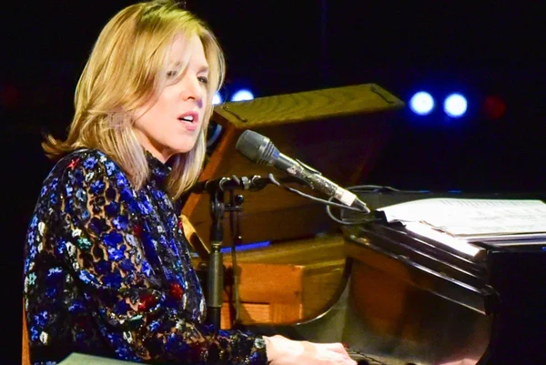 Foto colorida de Diana Krall tocando piano e cantando - Metrópoles