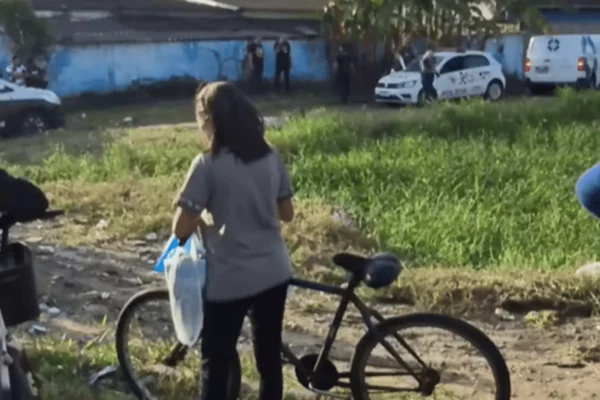 Imagem colorida de pessoas presentes na área onde o corpo do homem foi encontrado - Metrópoles