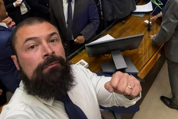 Homem com cabelo raspado e longa barba preta, na altura do peito - Metrópoles