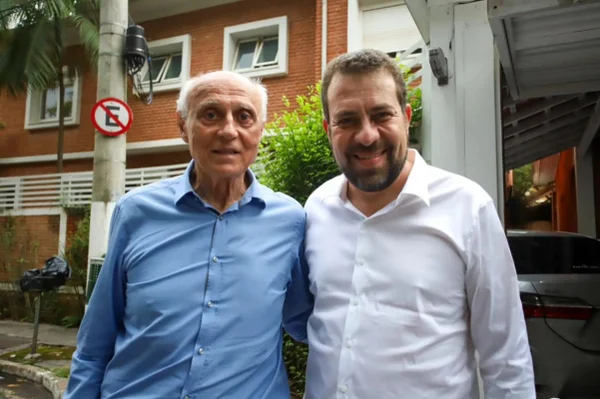 Imagem colorida mostra Edurdo Suplicy, branco idoso de camisa azul, e Guilherme Boulos, branco de cabelo e barba castanhos e camisa branca, posando para foto - Metrópoles