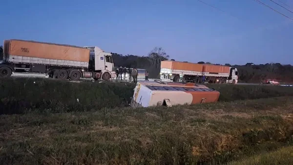 Imagem colorida de ônibus escolar capotado em pista - Metrópoles