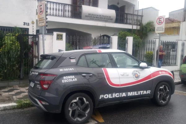 Imagem colorida mostra viatura em frente a casa onde homem foi preso acusado de agredir esposa e neto autista