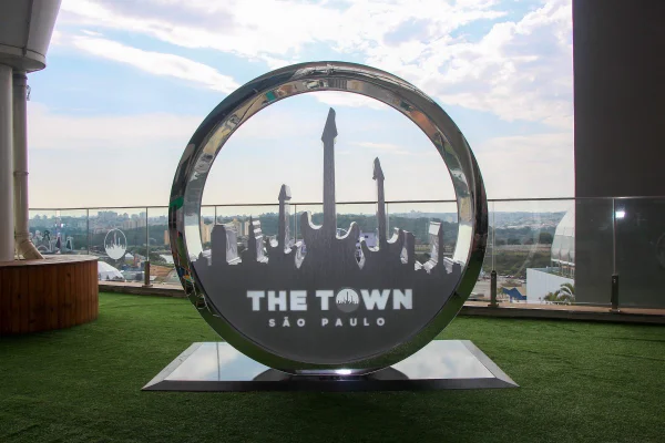 Imagem colorida mostra escultura redonda com logotipo do festival The Town em um piso que imita grama - Metrópoles